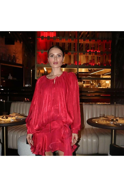 Frau im roten Éloïse Plissee Kleid in eleganter Restaurant-Umgebung