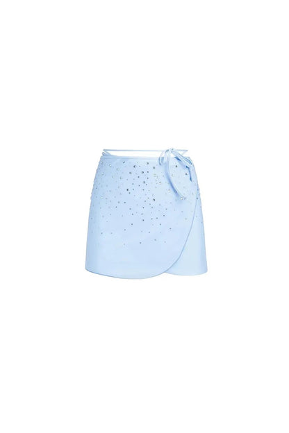 Miraee Paris light blue wrap mini skirt with sparkling diamond-effect embellishments for a glamorous beach look.