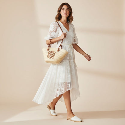 Miraee Paris Soleil beach bag in woven straw with brown leather handles carried by a woman in a white lace dress