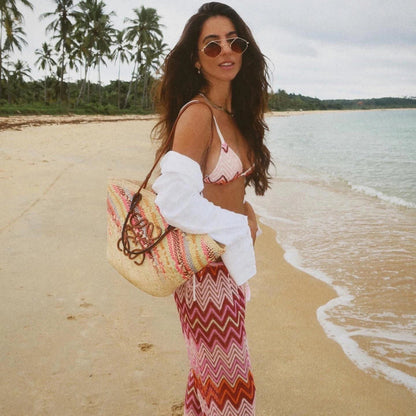 Miraee Paris 3-piece striped bikini set with mesh cover-up worn by a woman on a tropical beach with a straw tote bag.