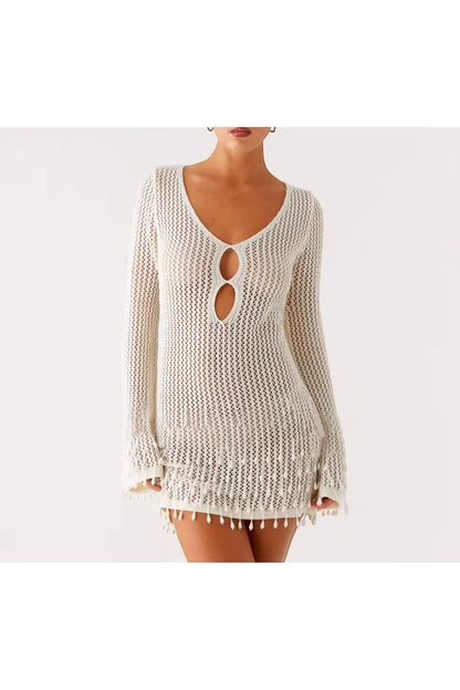 Miraee Paris white crochet beach cover-up with long sleeves, V-neckline, and tassel hem details on a model.