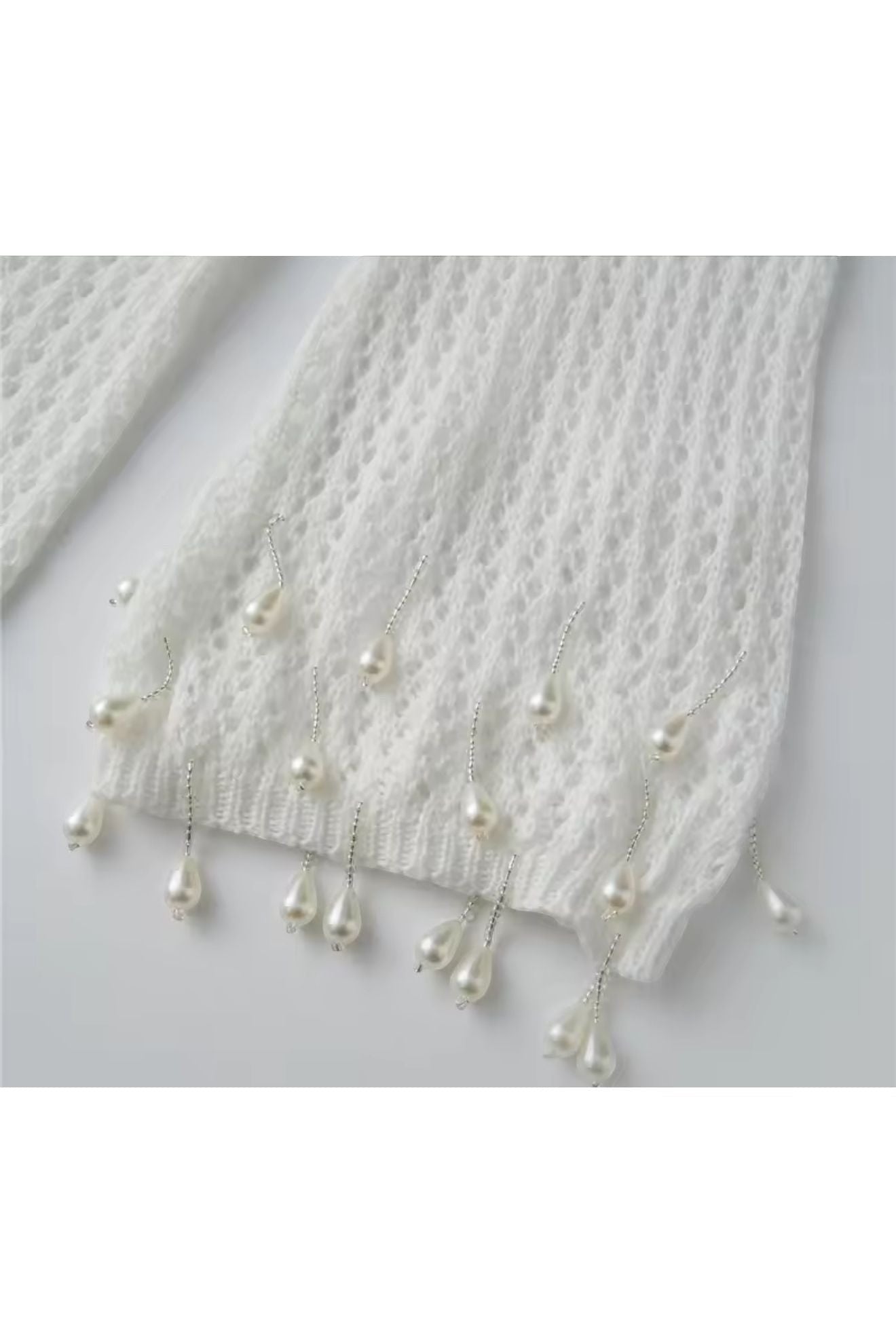 Miraee Paris white crochet cover-up sleeve detail with hanging pearl embellishments and delicate knit texture