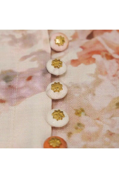 Detailansicht der Knöpfe eines eleganten Maxikleids mit floralem Print und Puffärmeln von Miraée.